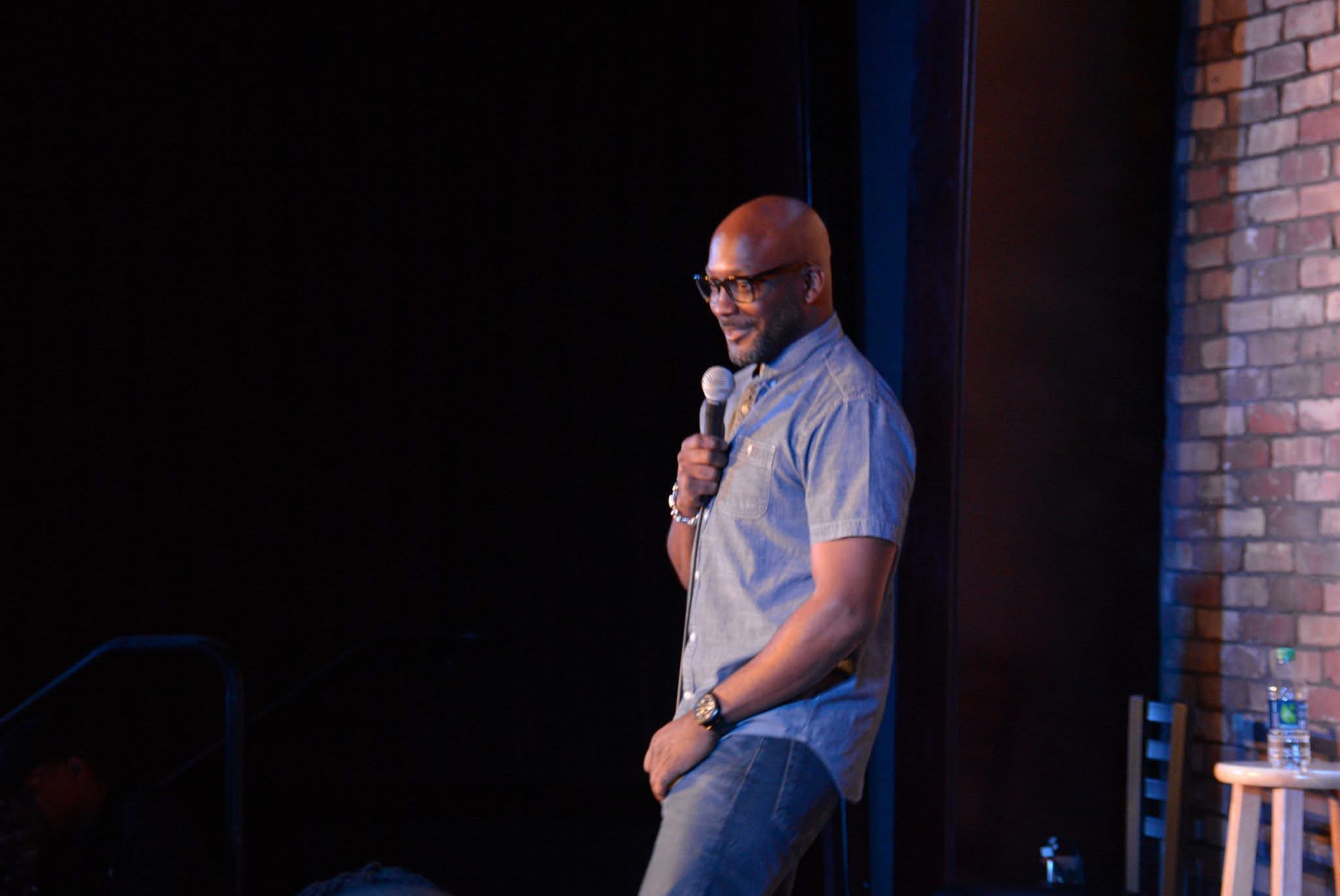 Michael McDaniel performing stand-up comedy on stage at a fundraiser event