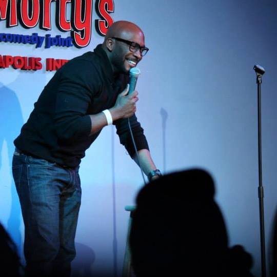 Comedian performing on stage at a comedy workshop event
